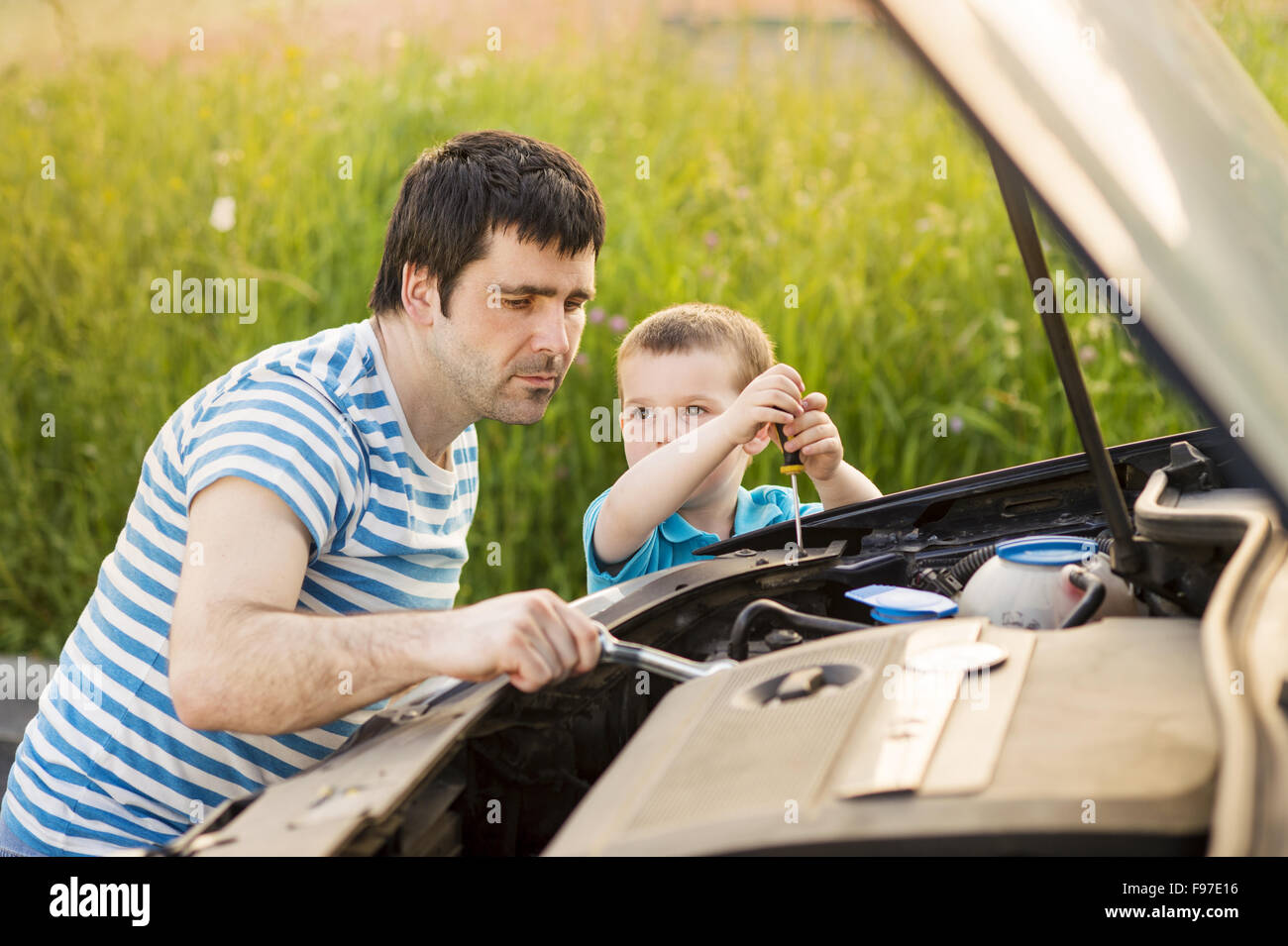 Giovane padre con il suo piccolo figlio di riparazione di auto Foto Stock