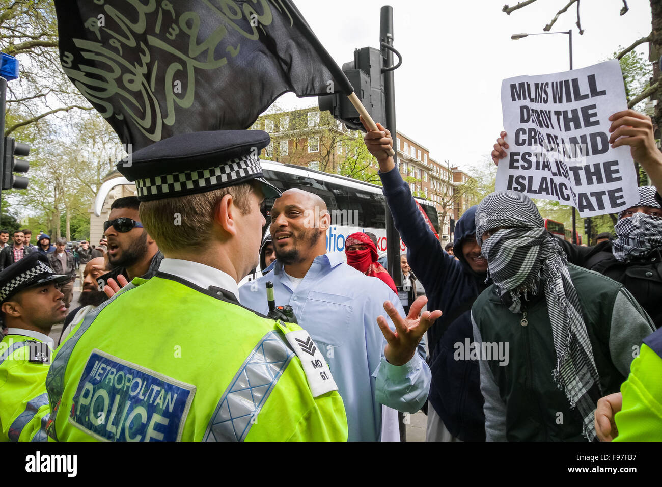 Londra, Regno Unito. Il 14 dicembre, 2015. File di immagini da 18 Aprile 2014: British-basata di islamisti Nadir Syed trovato colpevole di omicidio plot. Visto qui (destra in velo e giacca verde) durante uno scontro con la polizia e di estrema destra dei gruppi di protesta al di fuori di Regents Park moschea in London Credit: Guy Corbishley/Alamy Live News Foto Stock