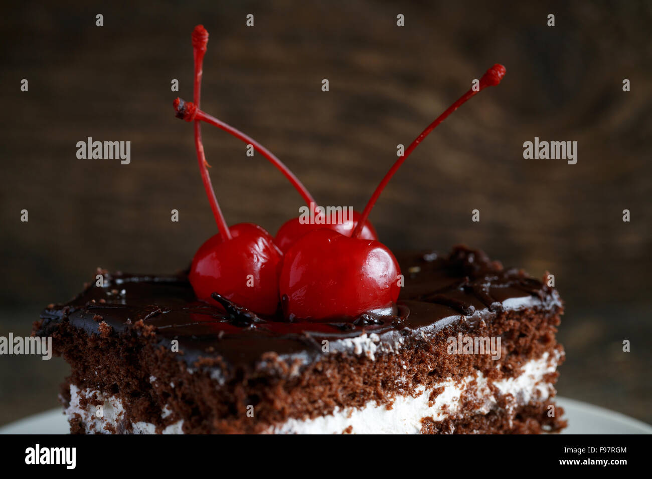 Squisite torte al cioccolato con cherry close-up su sfondo di legno Foto Stock