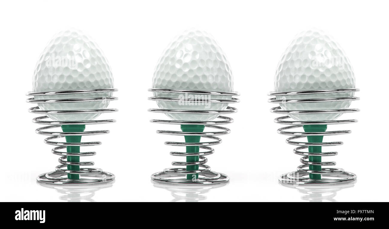 Golf Colazione - a forma di uovo palline da golf in coppe di uovo su sfondo bianco Foto Stock