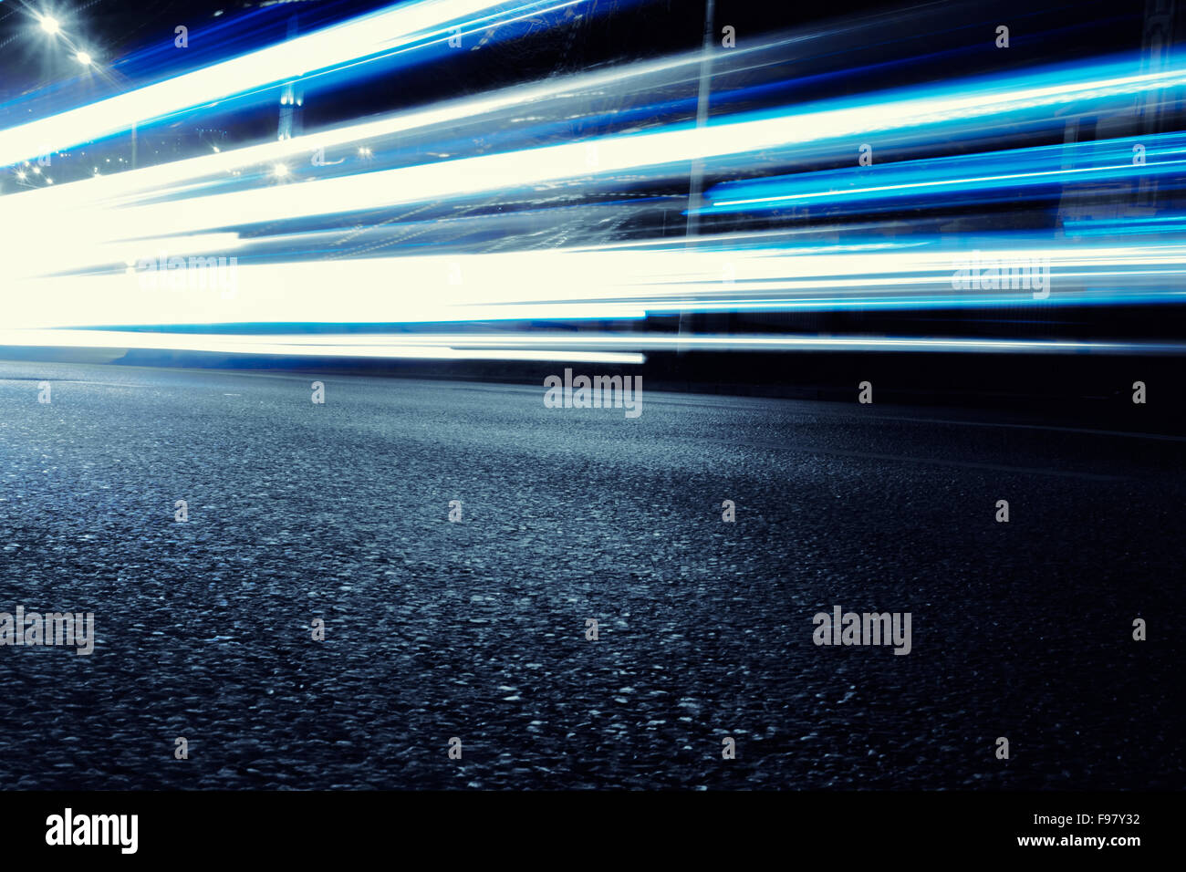 Vetture creano luce luce blu percorsi da i loro fari che si muovono in una città nel corso serale Foto Stock