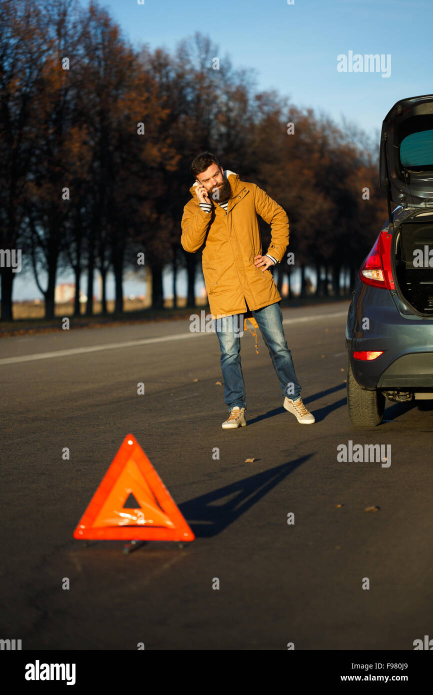 Autista uomo esaminando danneggiato automobili automobili dopo la rottura Foto Stock