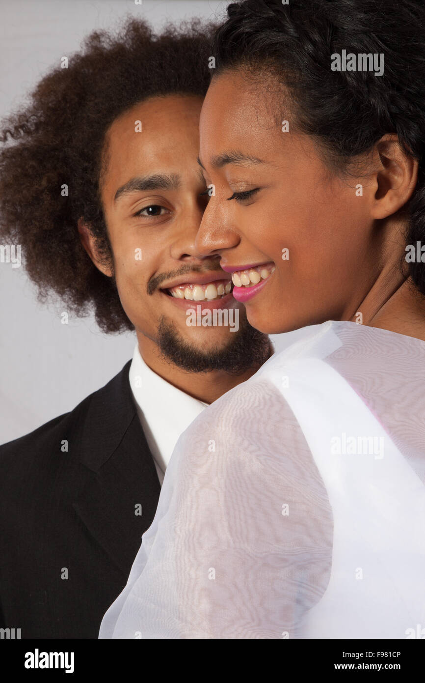 Nero romantico giovane, lei in un abito da sposa e toccando Foto Stock