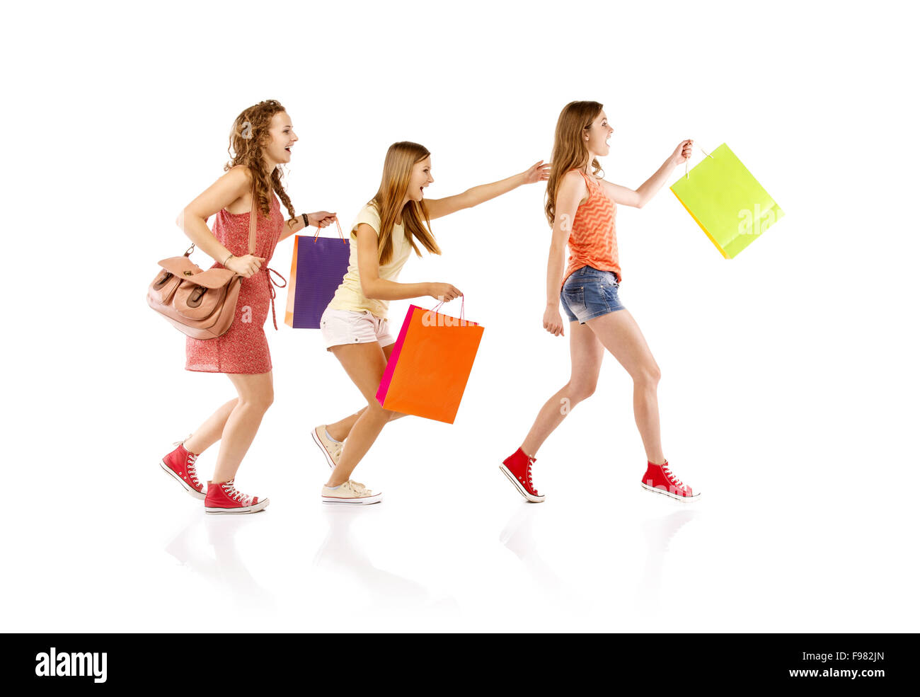 Gruppo di felice adolescente studenti donne in piedi e sorridente con shopping bags isolati su sfondo bianco. Foto Stock