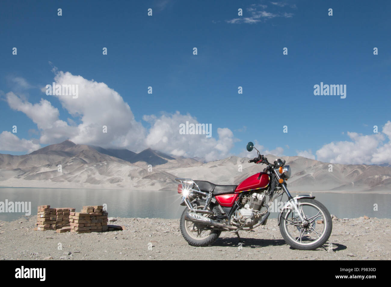 Moto di fronte lago, le montagne e il cielo blu Foto Stock