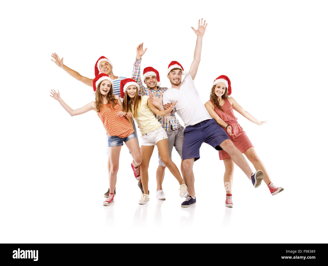 Un gruppo di giovani in cappelli di Babbo Natale il divertimento, isolato su sfondo bianco Foto Stock