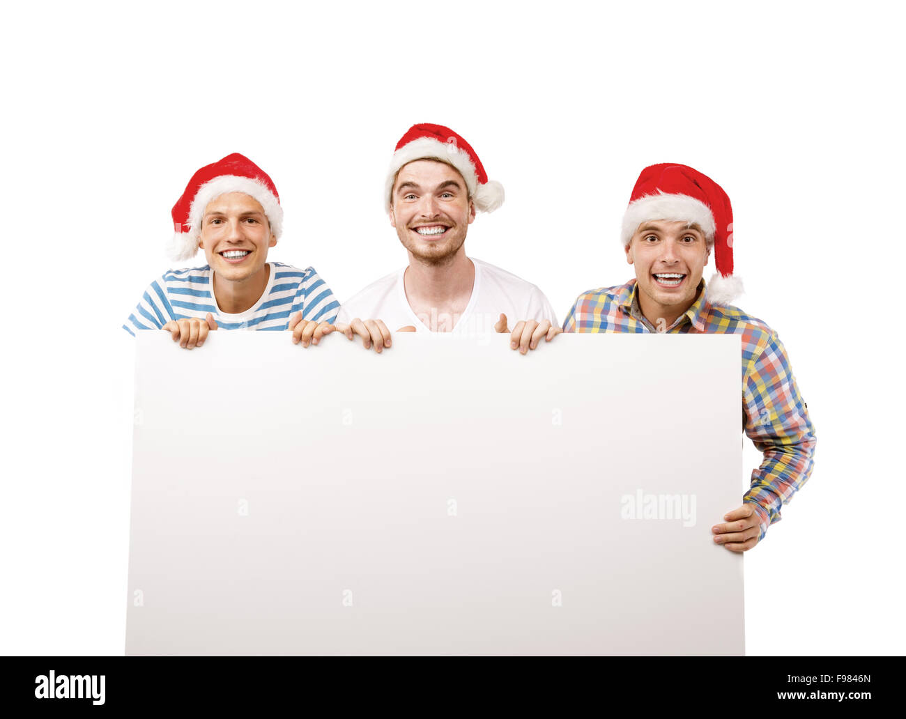 Tre giovani uomini in cappelli di Babbo Natale con copia spazio, isolati su sfondo bianco Foto Stock