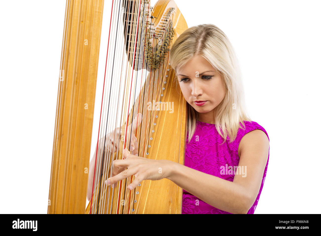 Donna elegante in abito viola suonare l'arpa, isolato su sfondo bianco Foto Stock