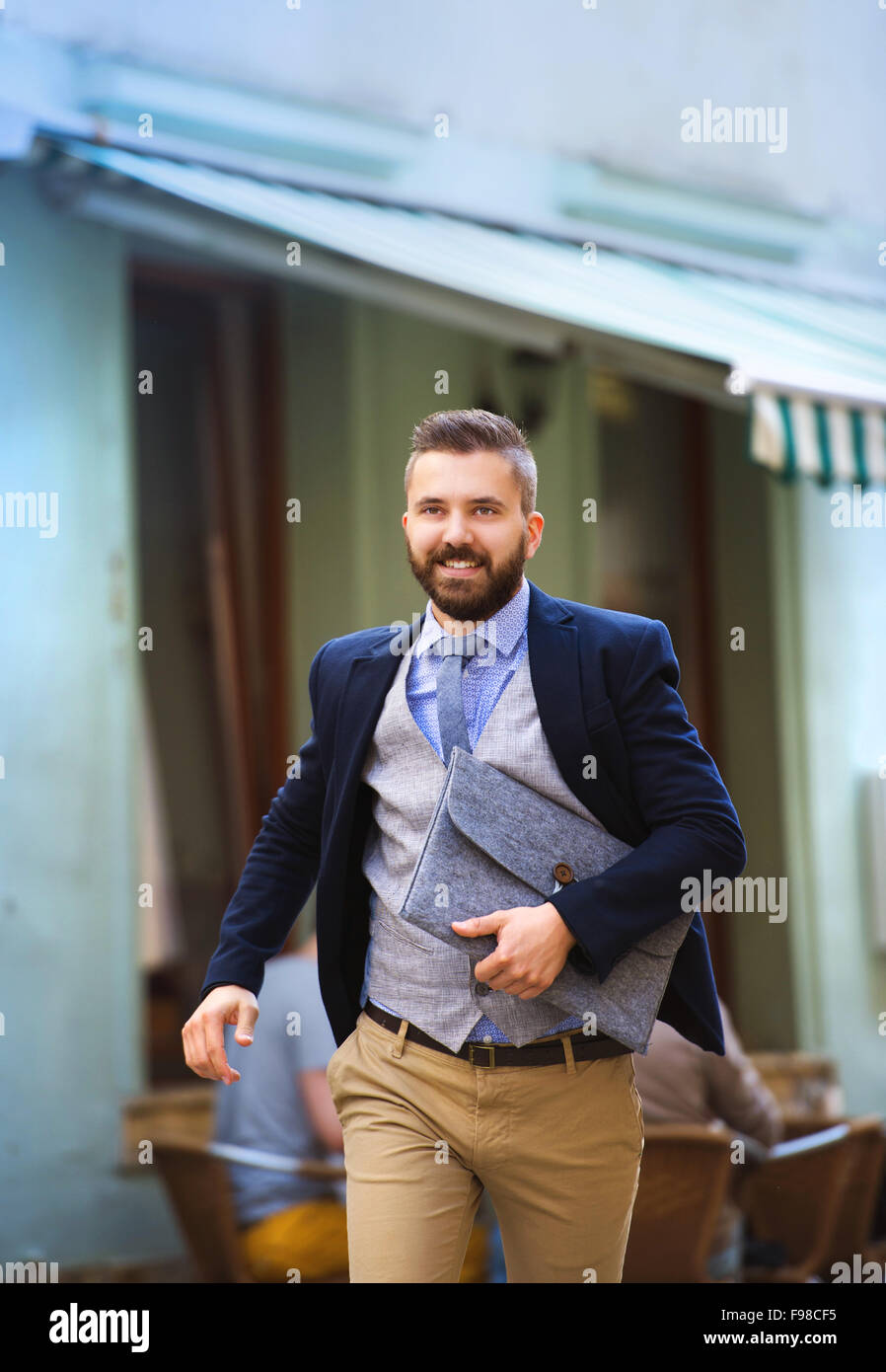 Bello e moderno imprenditore hipster con valigetta fretta al lavoro Foto Stock