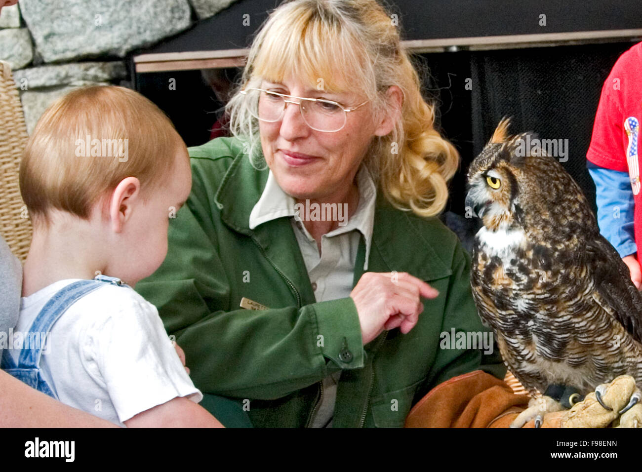 Un ranger del parco offre una natura parlare di uccelli rapaci e mostra un gufo cornuto ad un giovane bambino a Amiclola Falls State Park. Foto Stock