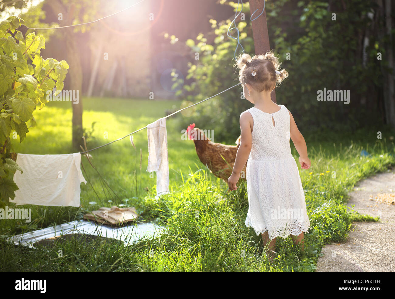 Felice bambina divertendosi nel giardino vicino alla vecchia casa colonica Foto Stock