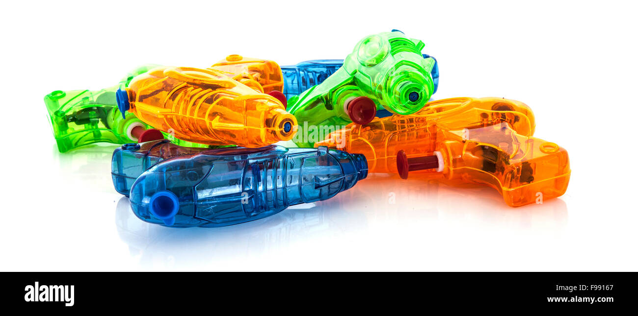 Pila di plastica colorata pistole ad acqua su sfondo bianco Foto Stock