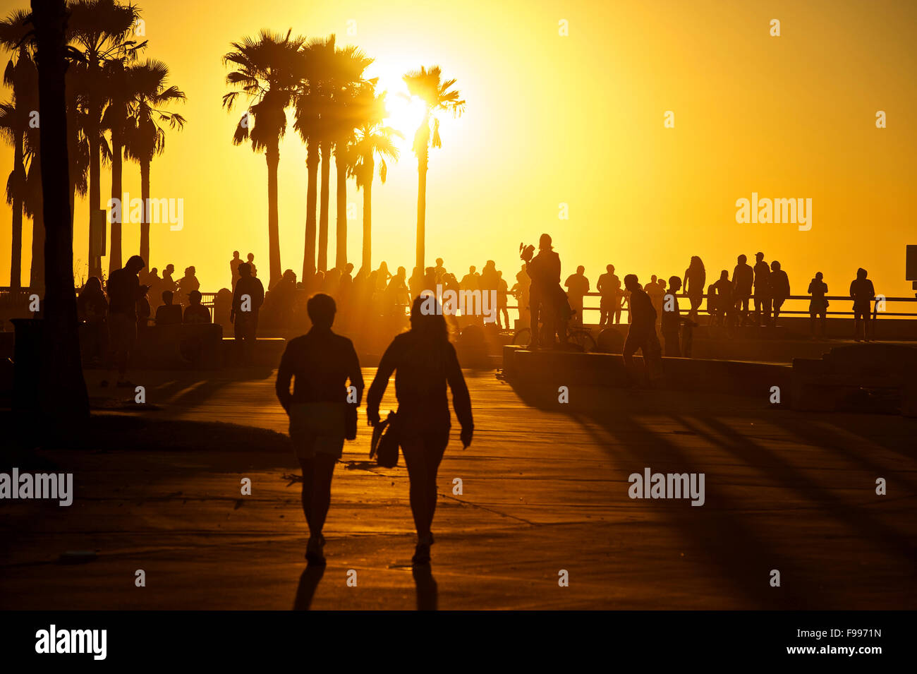 La gente a piedi verso la Venezia Skate Park al tramonto lungo la spiaggia di Venice, California. Foto Stock