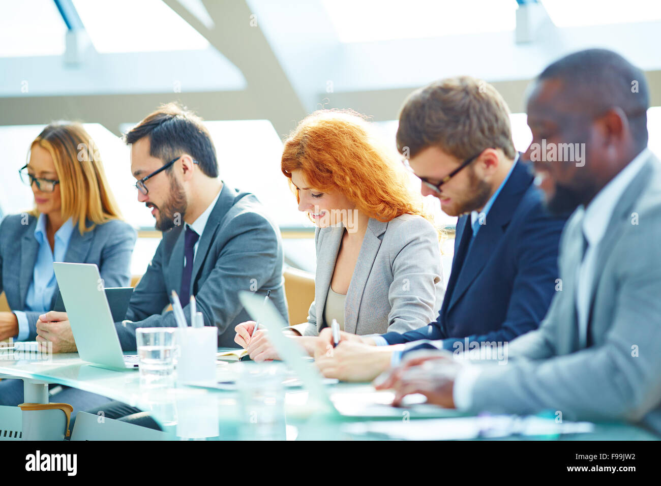 Giovani imprenditori creare delle note durante la lezione Foto Stock