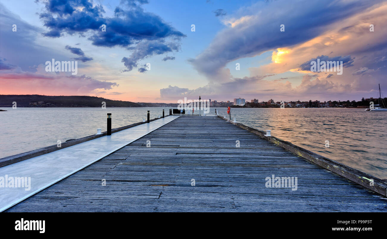 Ampia molo in legno guardando verso il porto di Sydney a storico sito australiano della stazione di quarantena al tramonto. Questo museo è Foto Stock