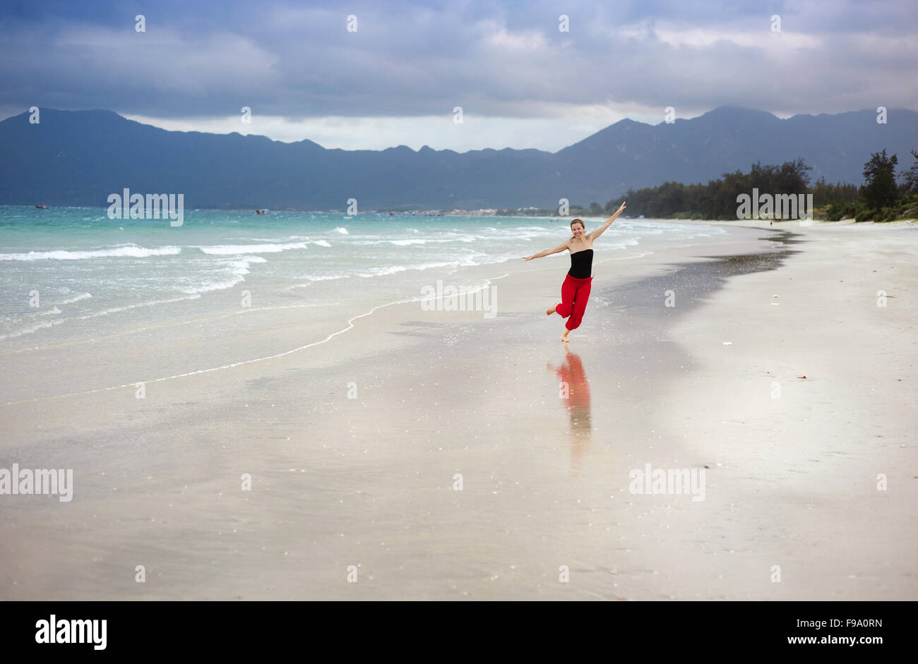Bella giovane donna sta godendo del tempo libero presso la splendida spiaggia di sabbia Foto Stock