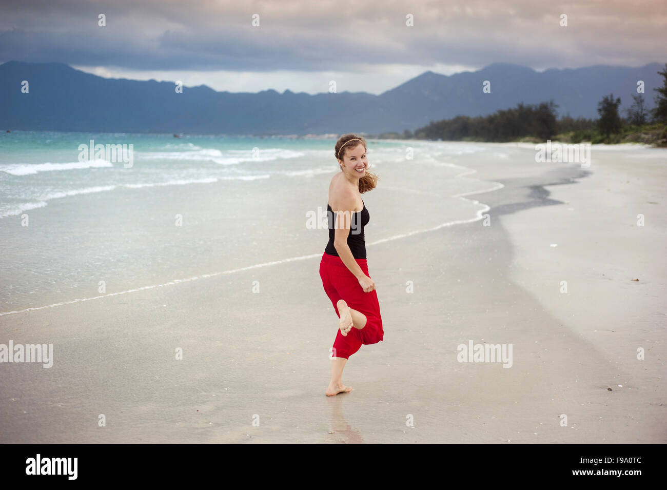 Bella giovane donna sta godendo del tempo libero presso la splendida spiaggia di sabbia Foto Stock