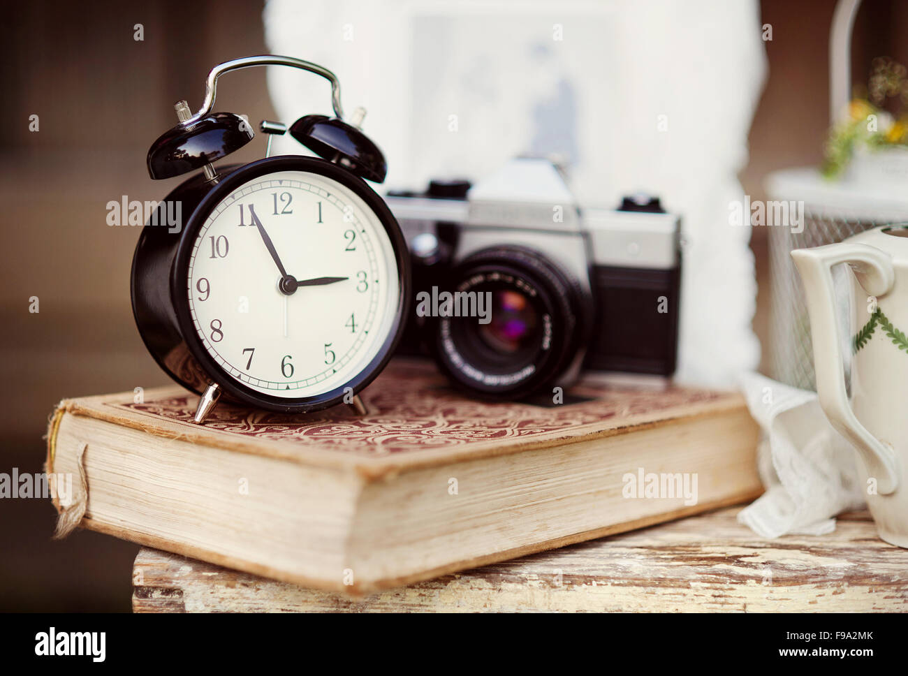 Gruppo di oggetti su vintage tavolo in legno. vecchio orologio sveglia, fotocamera retrò, prenota Foto Stock