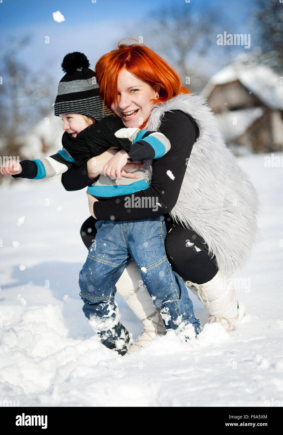 Felice madre con bambino divertirsi al di fuori nella neve Foto Stock