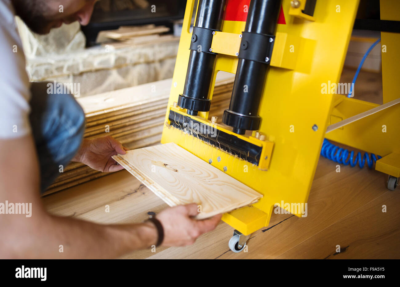 Close up handymans mani incollaggio di pavimenti in legno Foto Stock