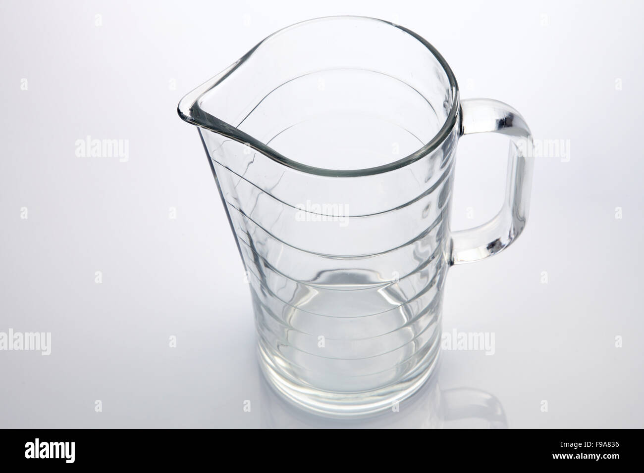 Vetro di acqua brocca su sfondo bianco Foto Stock