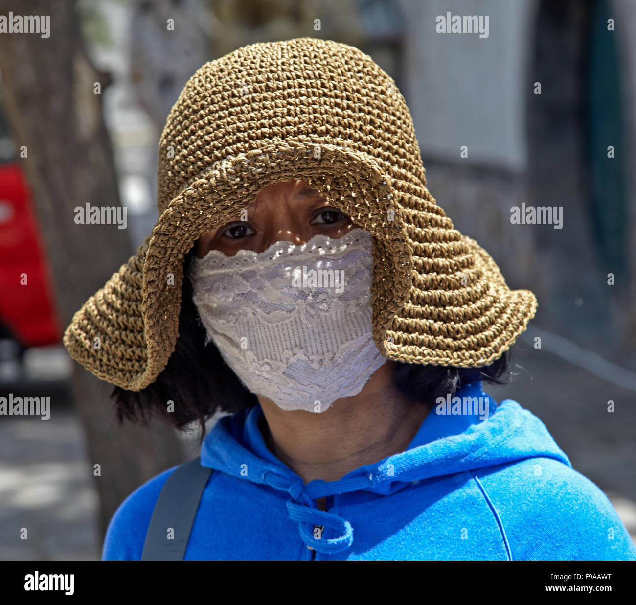Donna cinese che indossa la maschera per il viso contro lo smog, Cina Foto Stock