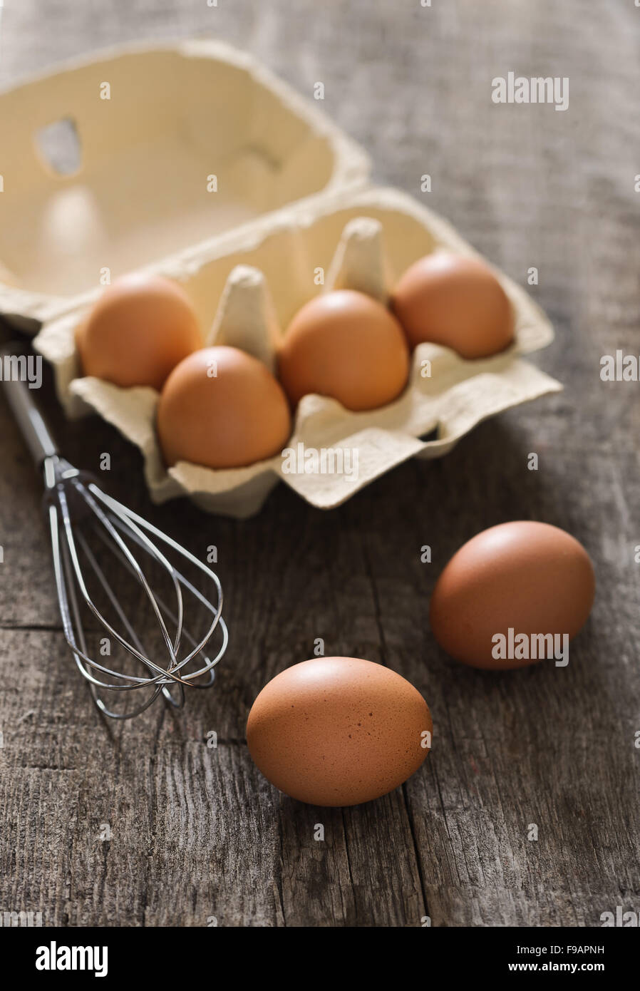 Composizione marrone con le uova e mescolare con una frusta sul vecchio backgrou rustico Foto Stock