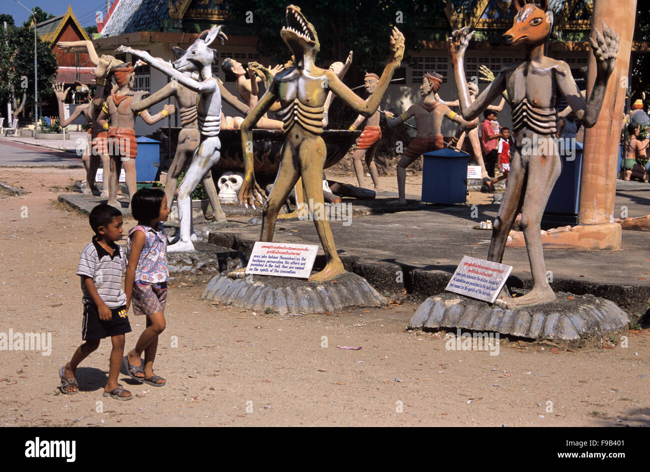 I bambini tailandesi che visitano il Giardino dell'Inferno con statue concrete di peccatori reincarnati come animali. Scultura d'arte popolare di kitsch nel Giardino dell'Inferno di Wat Wang Saen Suk nei terreni del Tempio, Bang Saen, Chonburi Thailandia Foto Stock