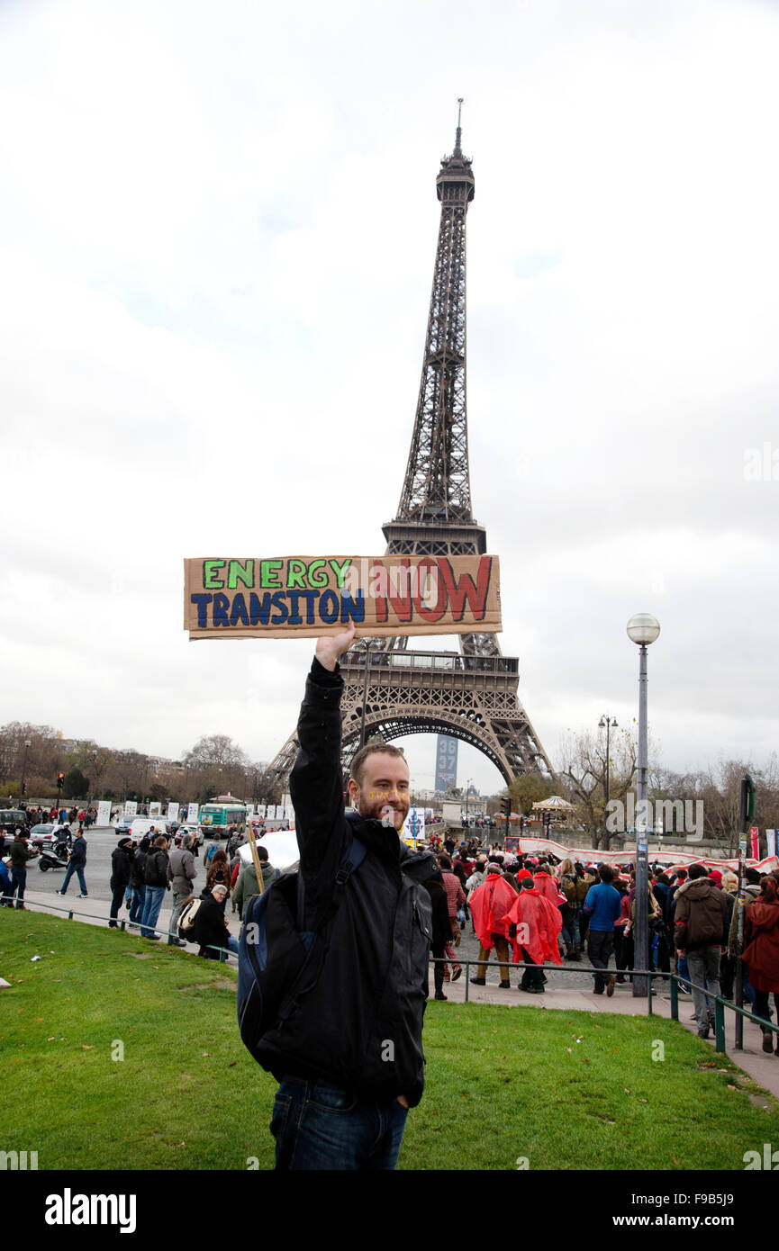 D12 giorno di azione disegno linee rosse in tutta Parigi. Uomo di fronte alla Torre Eiffel con il cartello che diceva "l'energia ora di transizione". Foto Stock