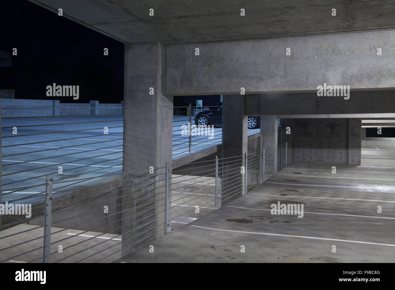 Auto parcheggiate in una struttura di parcheggio di notte Foto Stock