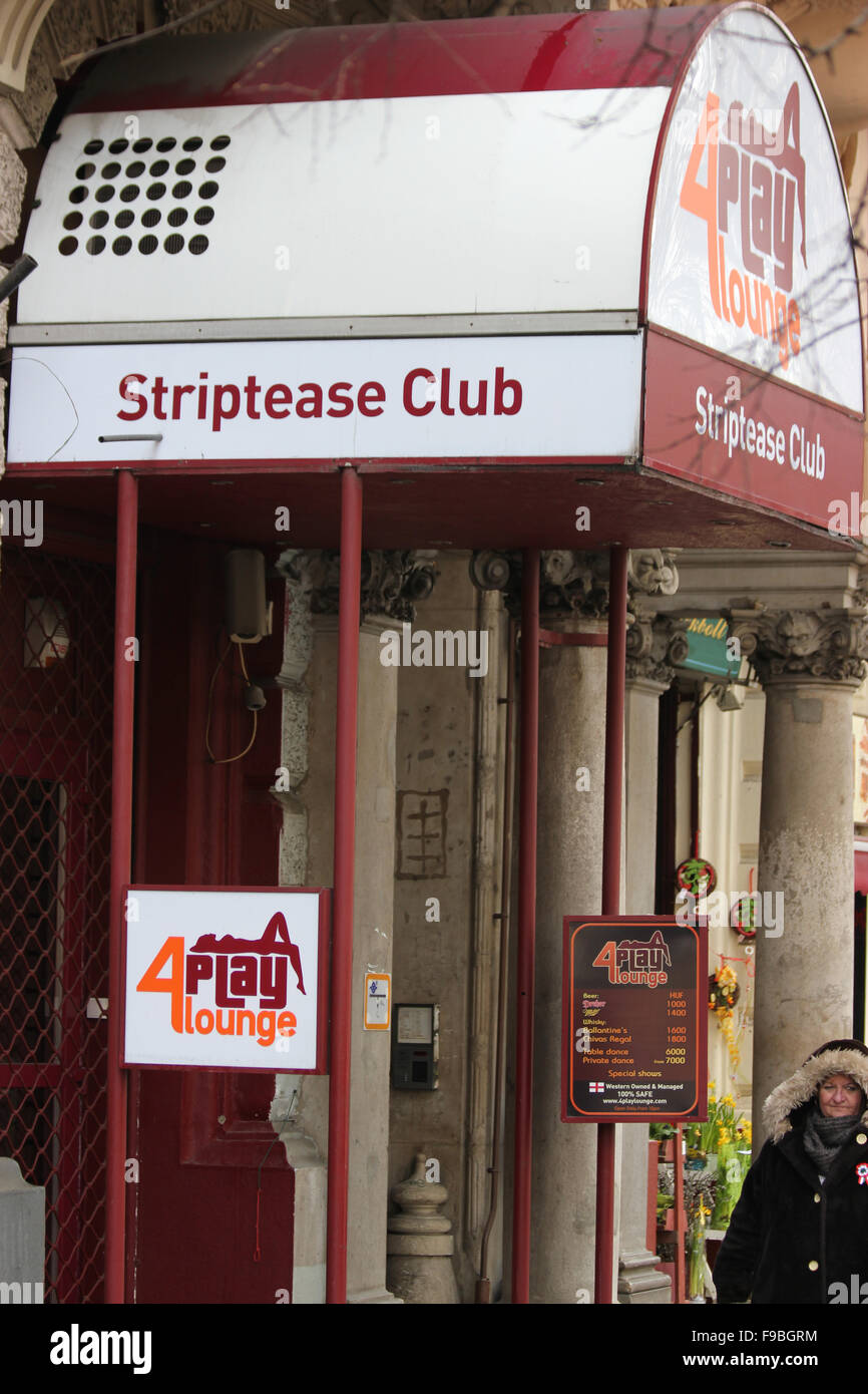 Una donna cammina passato un striptease club di Budapest Foto Stock