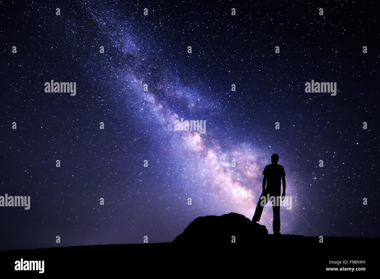 Via Lattea. Cielo notturno con stelle e la silhouette di un uomo con in rilievo le armi Foto Stock