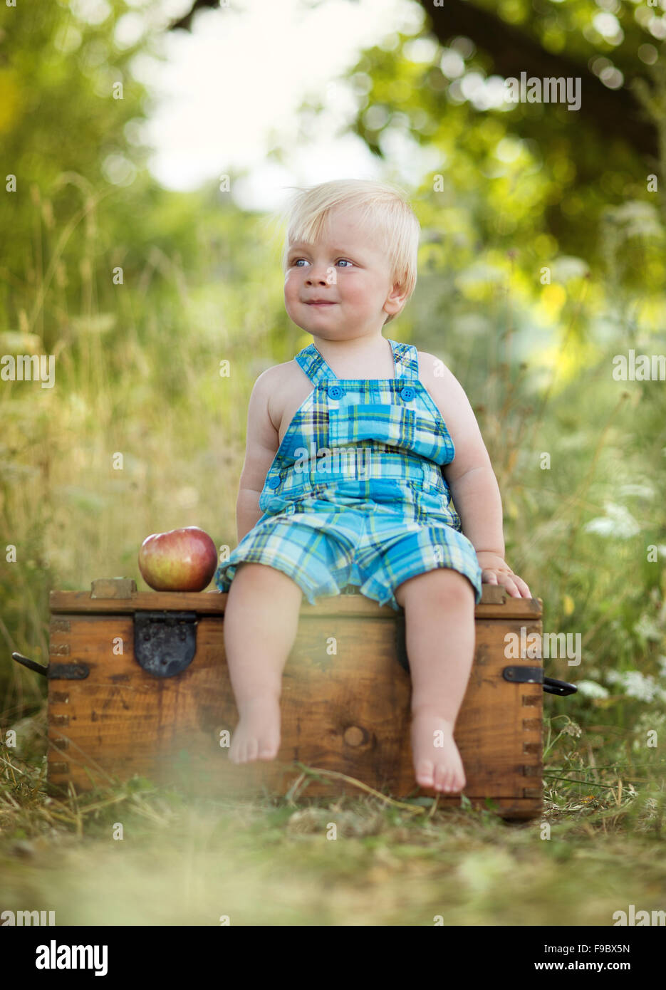 Carino kid tenendo un red apple nel parco verde Foto Stock