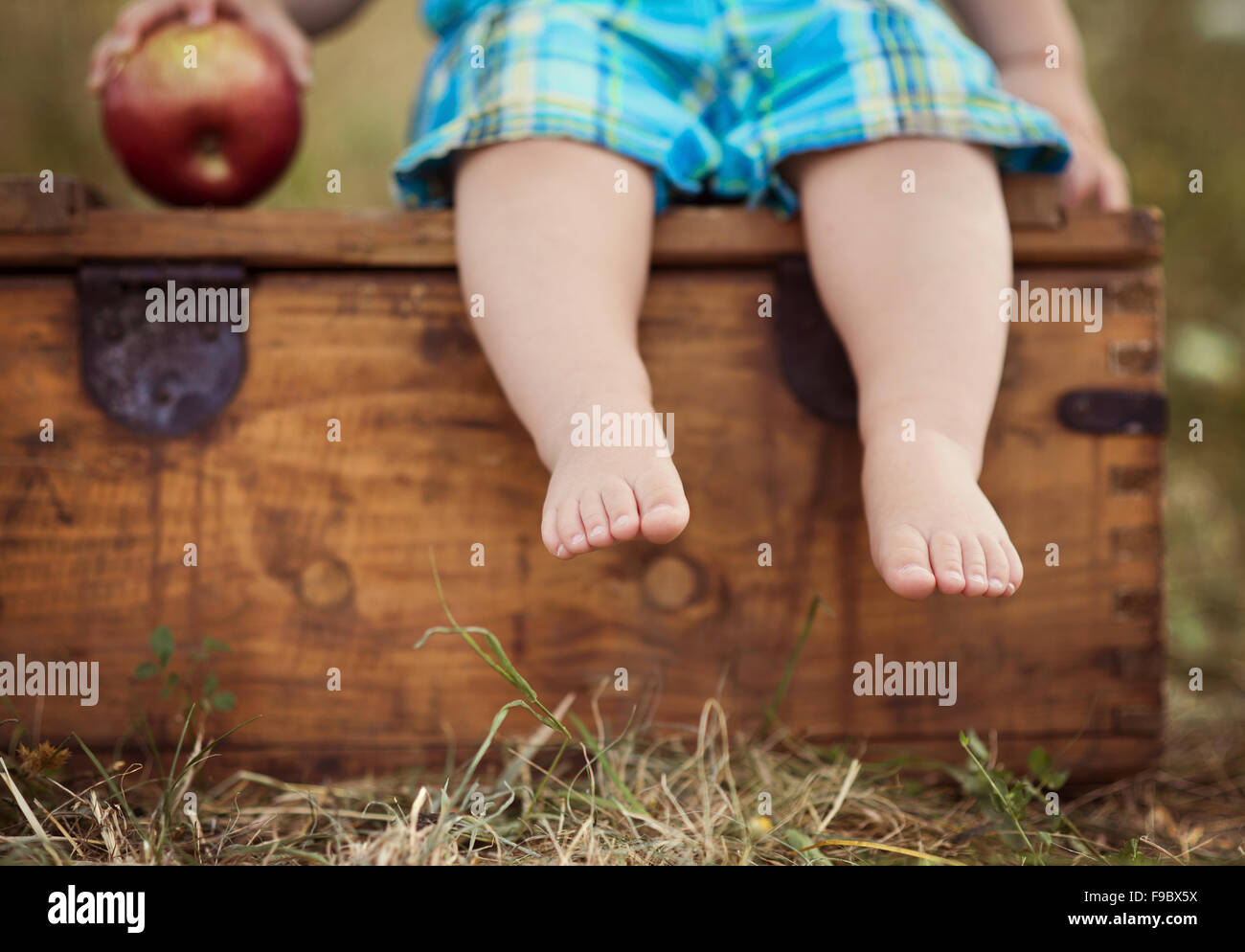 Carino kid tenendo un red apple nel parco verde Foto Stock