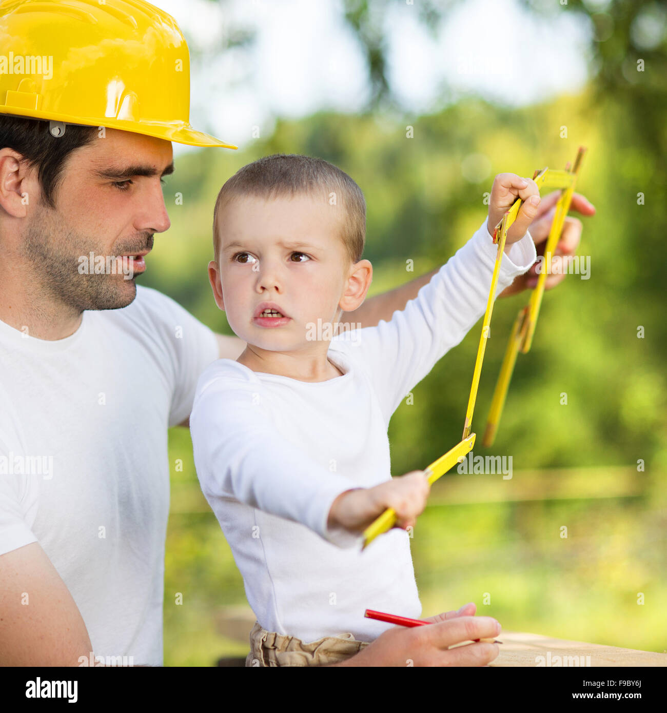Piccolo figlio di aiutare il padre con i lavori di costruzione Foto Stock