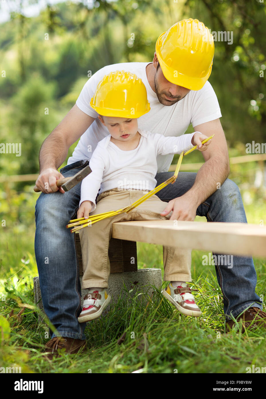 Piccolo figlio di aiutare il padre con i lavori di costruzione Foto Stock