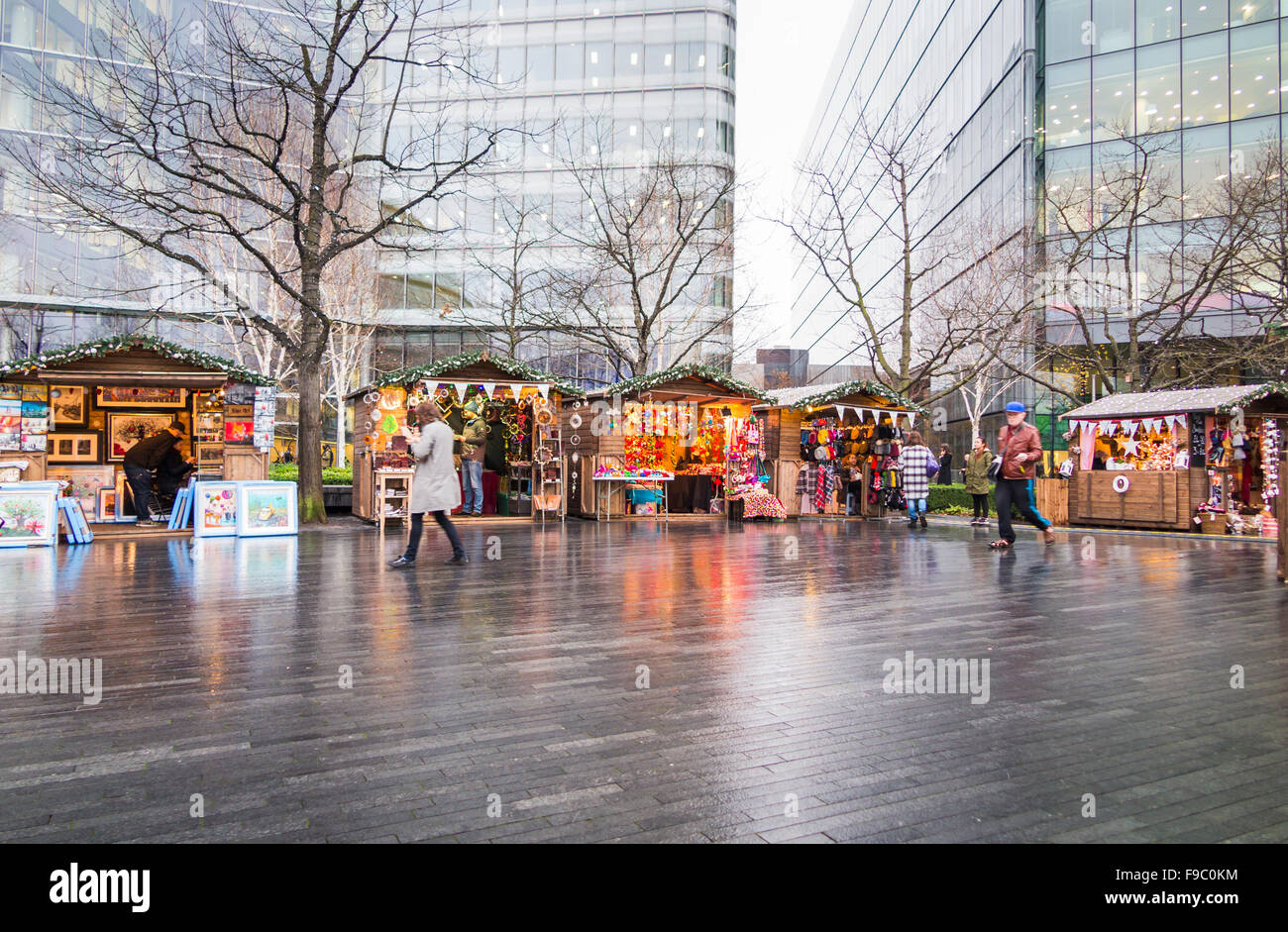 Si spegne al tramonto di sera presto, London Bridge città mercato di Natale, London Borough di Southwark, SE1 su un umido giornata invernale con riflessi luminosi Foto Stock