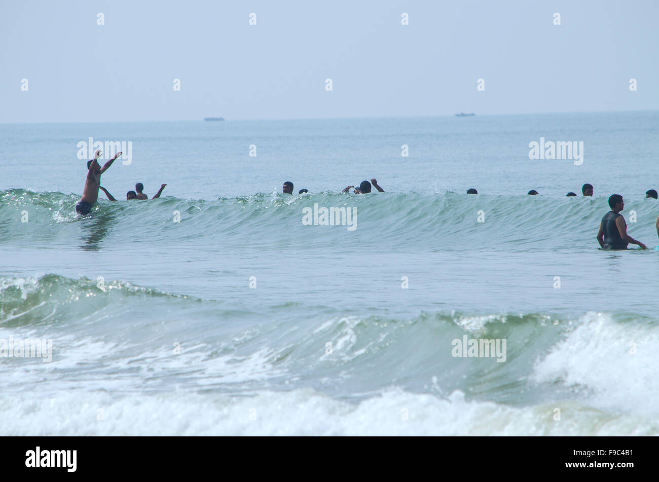Persone nuotare sulle onde del mare Foto Stock