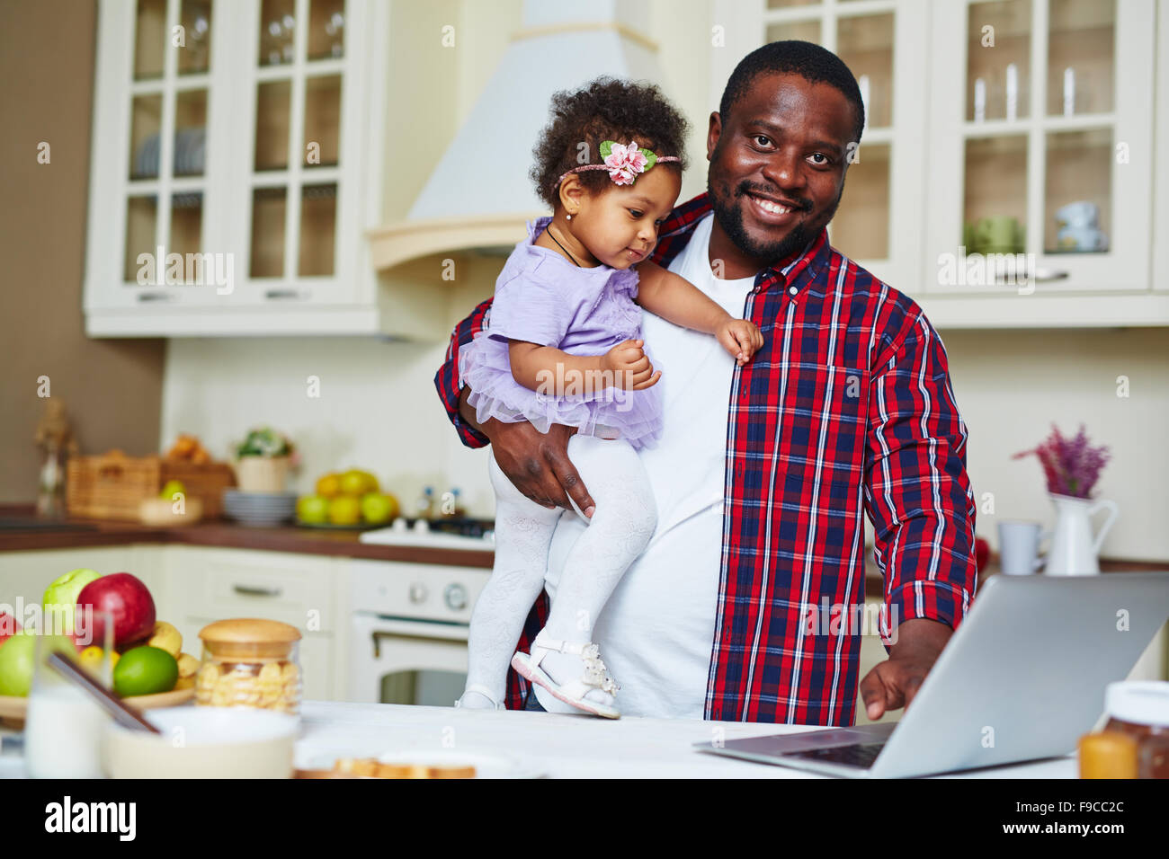 Giovane uomo con la sua piccola figlia di networking in cucina Foto Stock