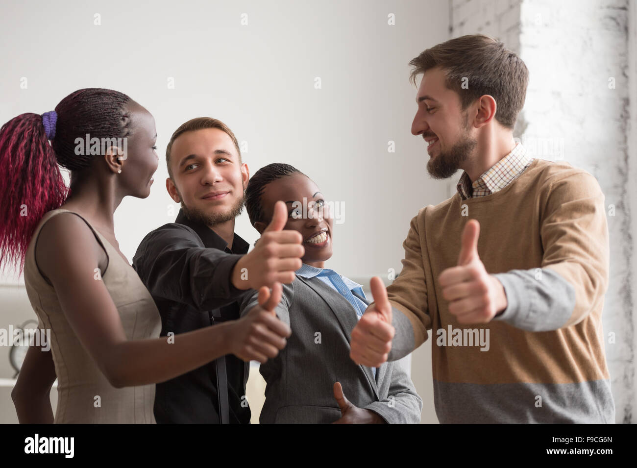 Allegro gruppo aziendale dando pollice in alto Foto Stock