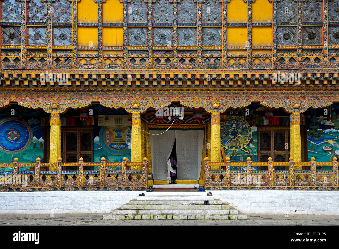 Uomo locale all'ingresso del tempio di incoronazione presso il monastero e fortezza di Punakha Dzong, Punakah, Bhutan Foto Stock