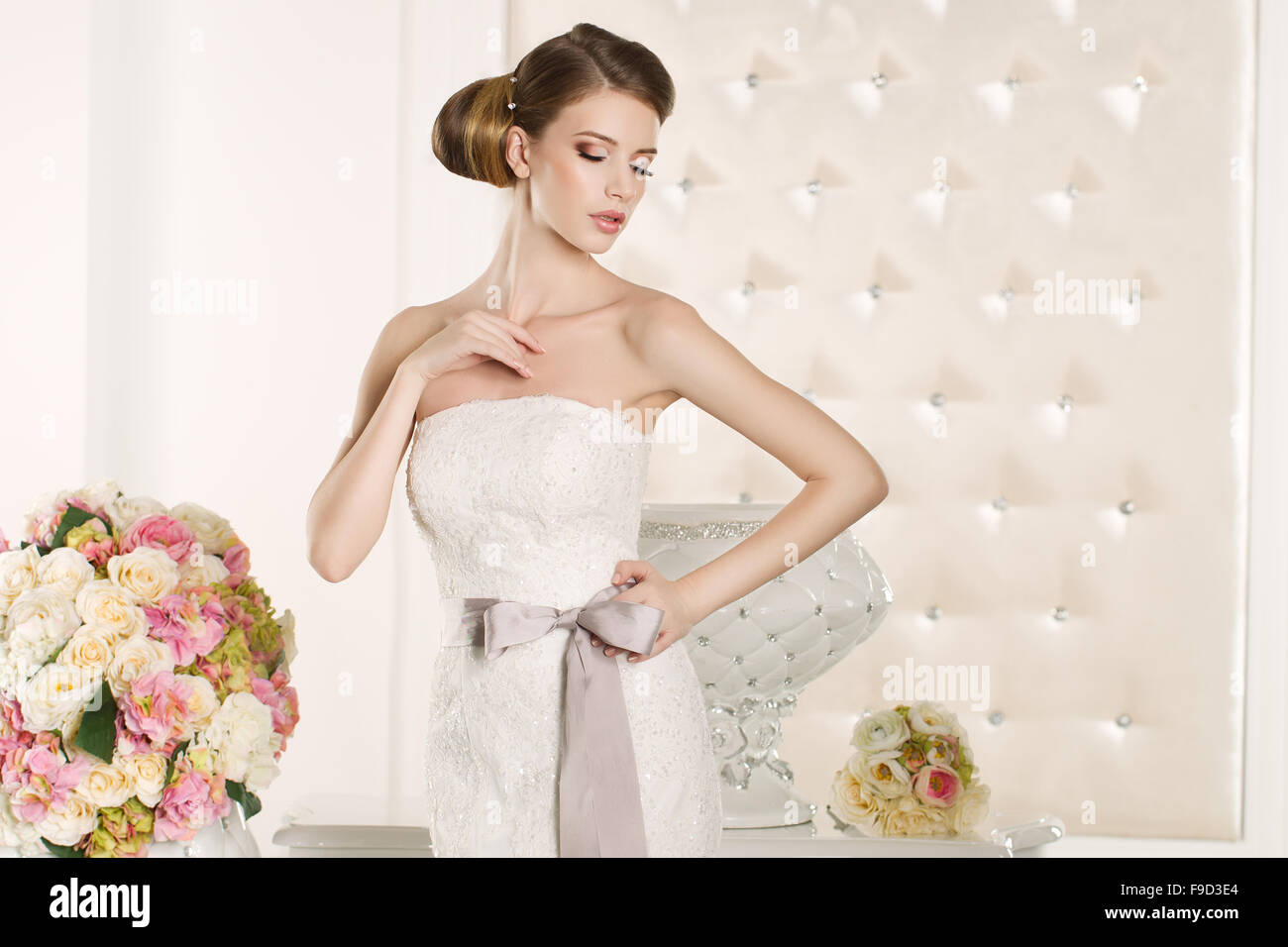 Splendida sposa con abito bianco con bouquet di fiori Foto Stock