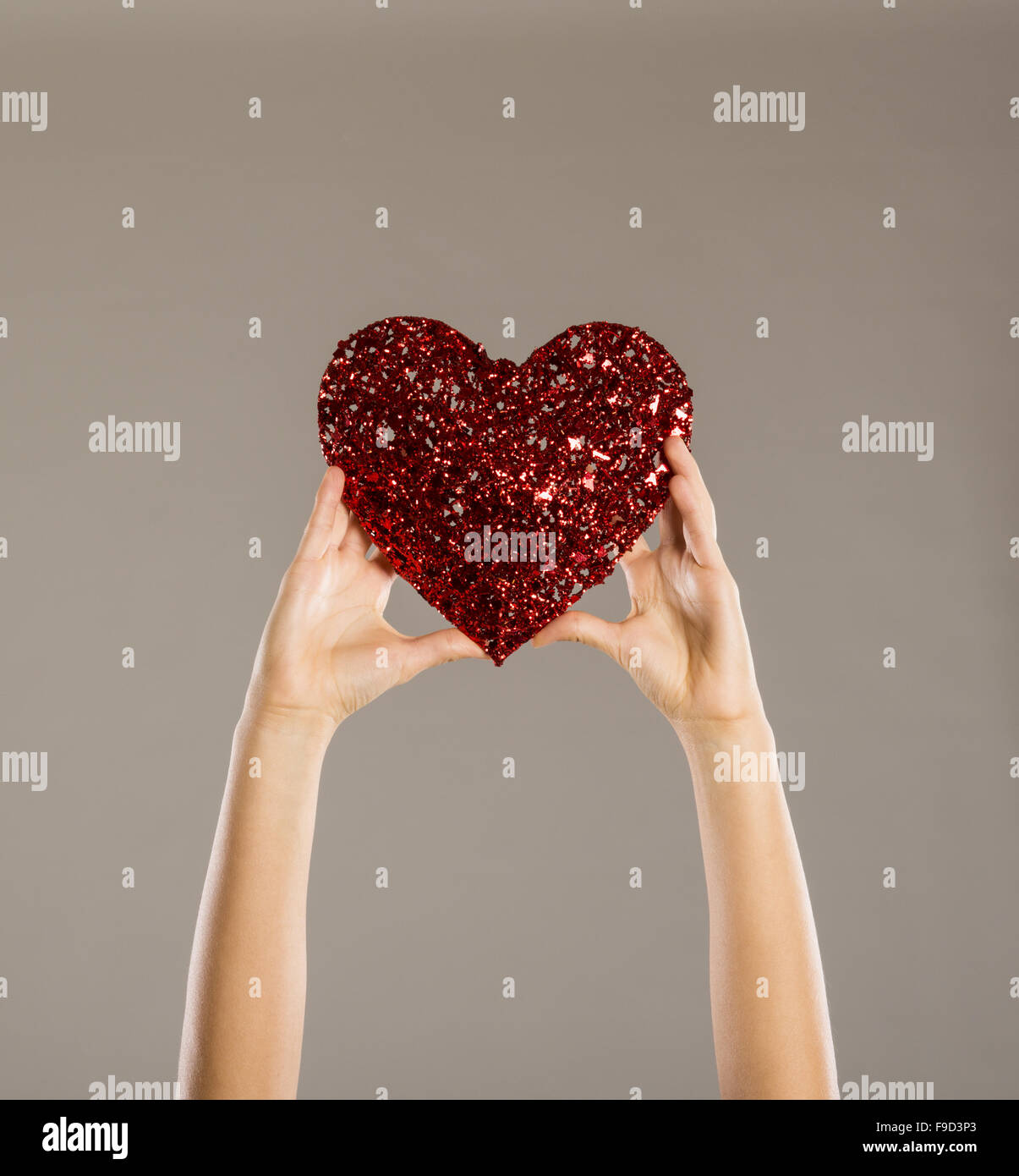 Cuore rosso nelle mani di una donna, close up Foto Stock