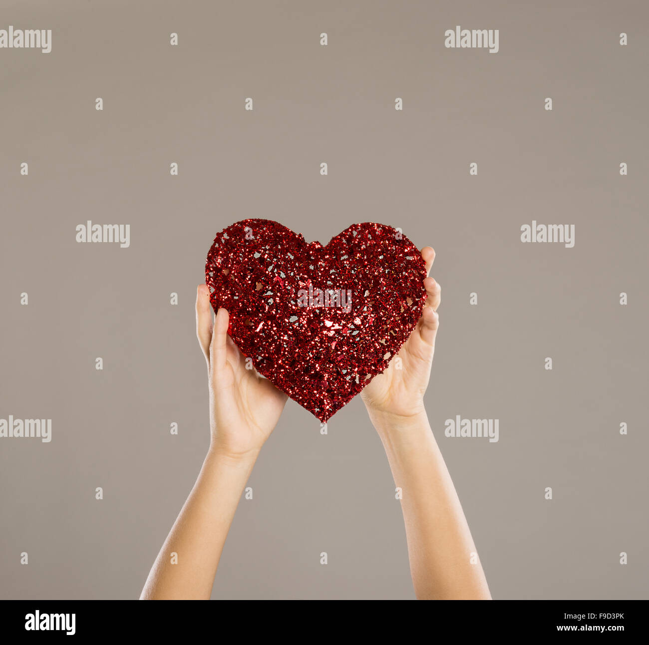 Cuore rosso nelle mani di una donna, close up Foto Stock