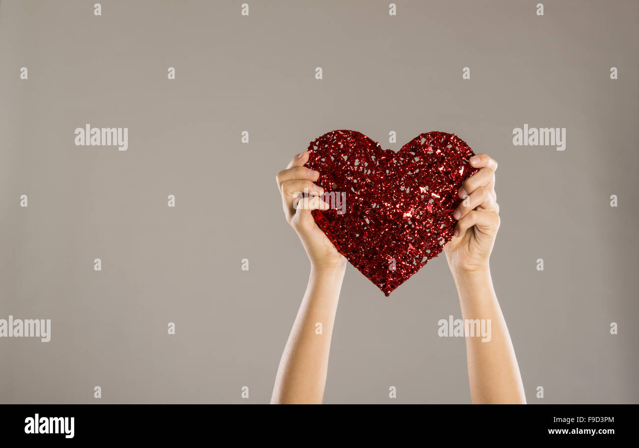 Cuore rosso nelle mani di una donna, close up Foto Stock