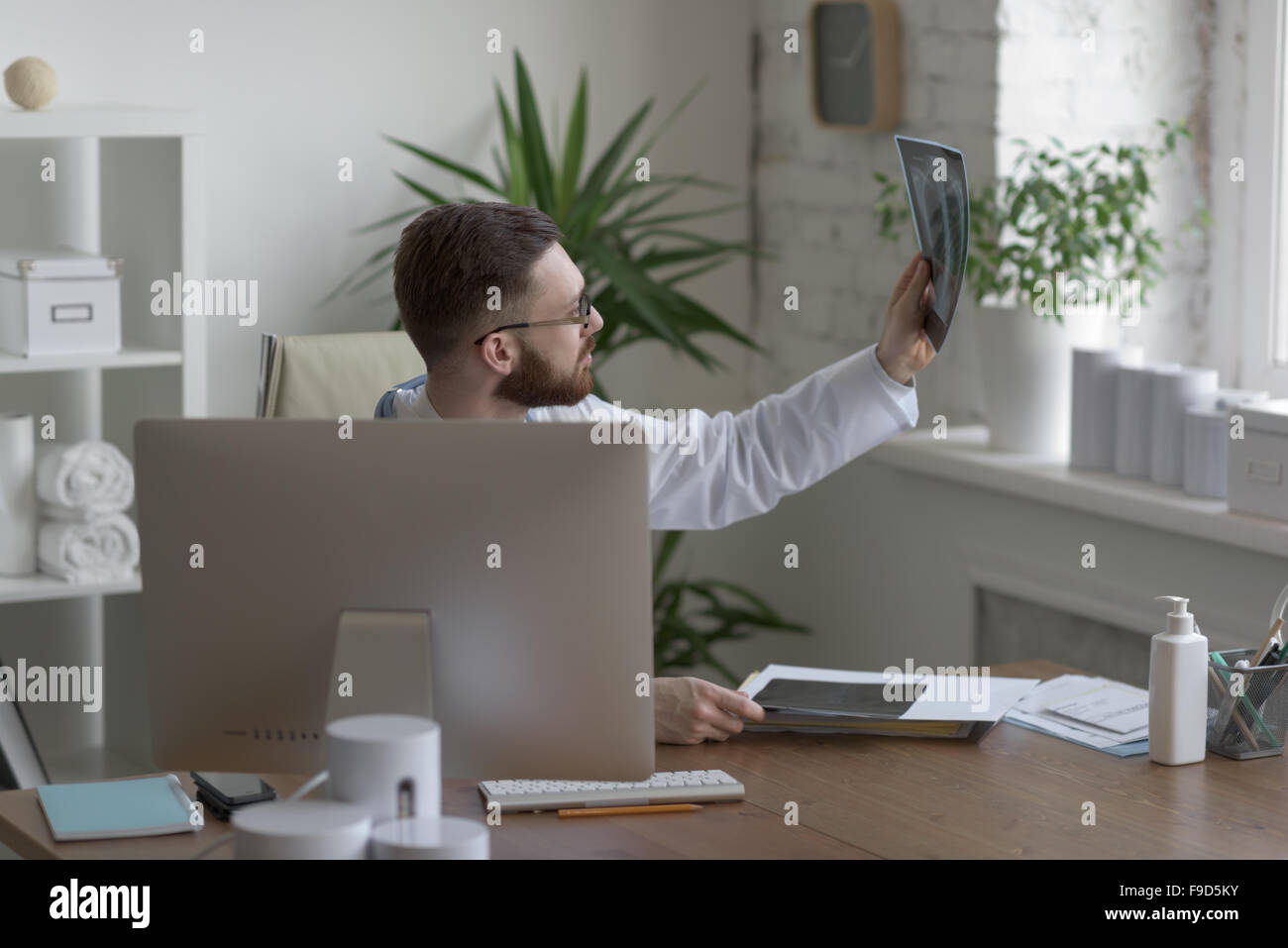 Riflessivo medico tenendo il petto e polmoni xray in ufficio medico Foto Stock