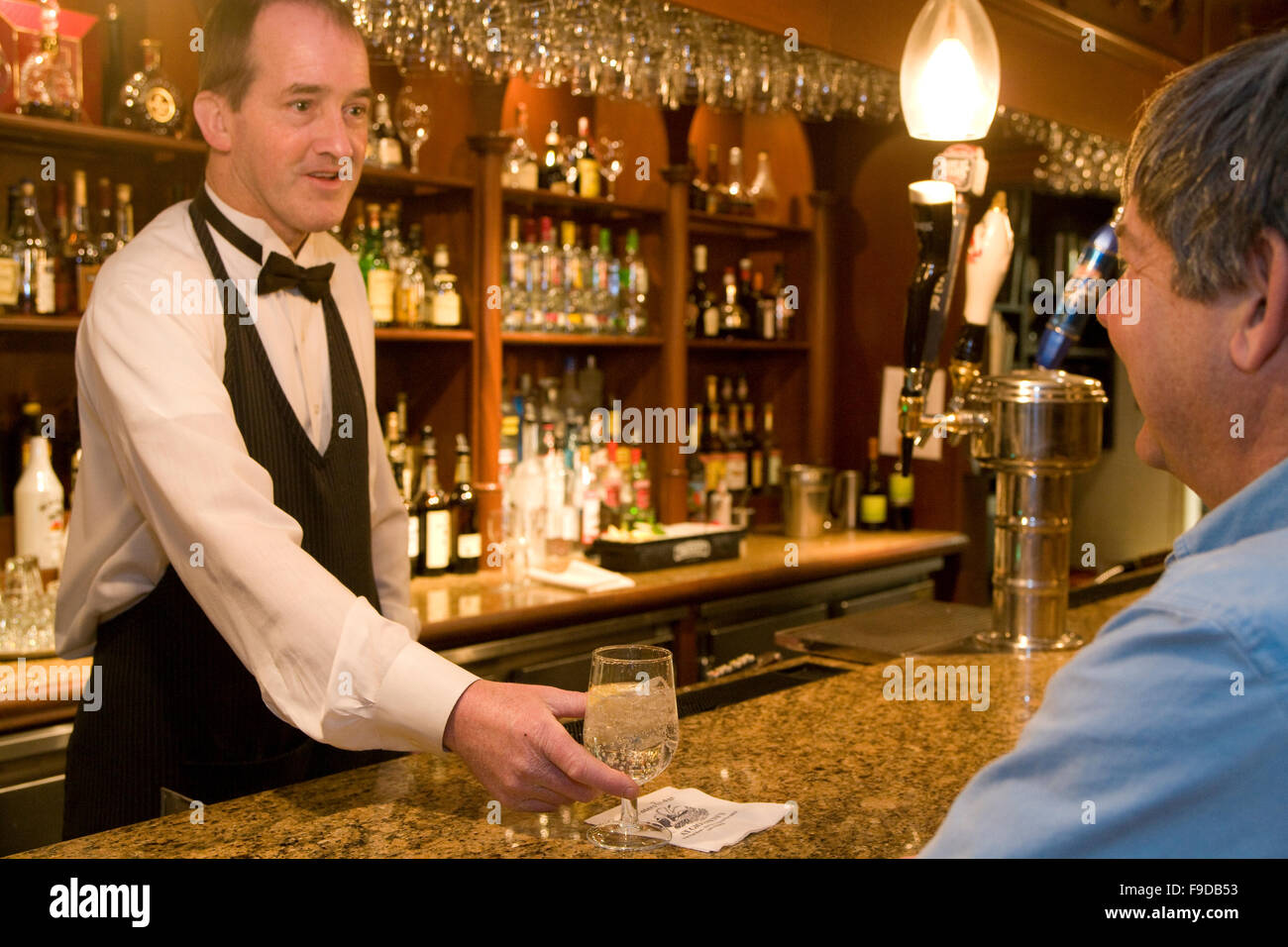 Il Barman che serve bevande Foto Stock
