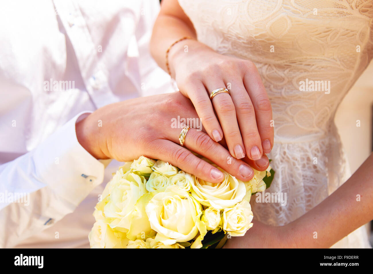 Le mani e gli anelli sul mazzo di nozze close up Foto Stock
