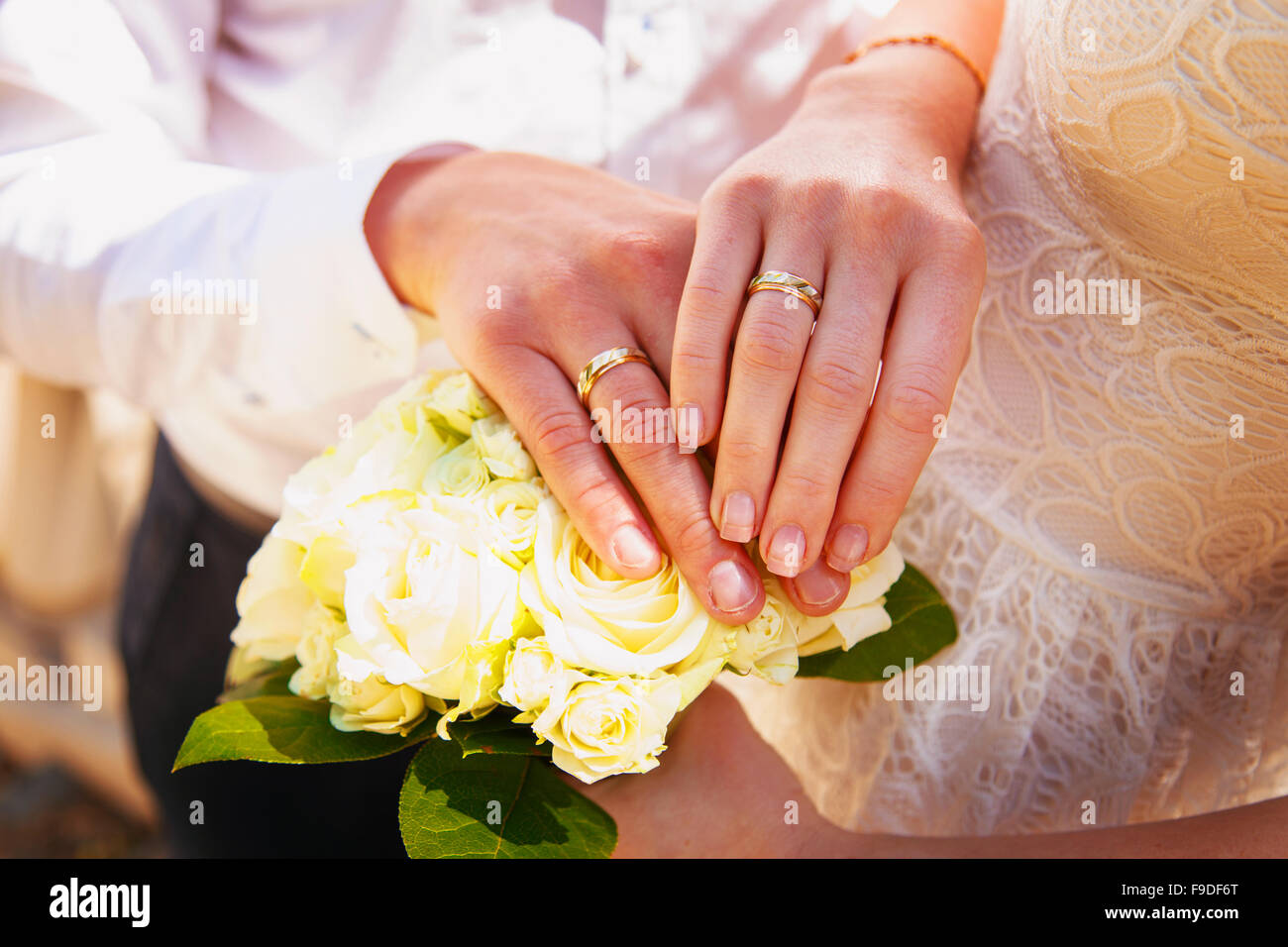 Le mani e gli anelli sul mazzo di nozze close up Foto Stock