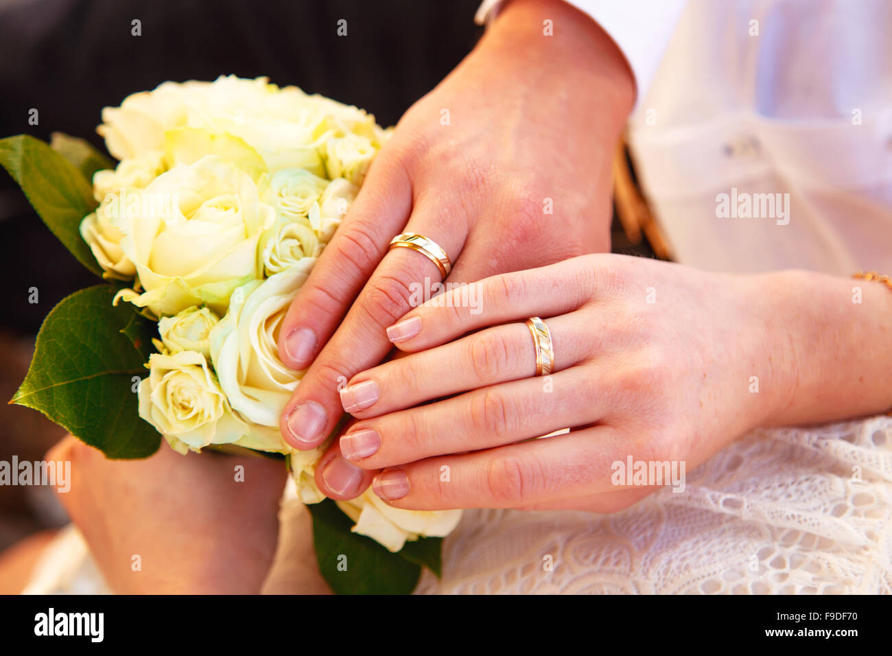 Le mani e gli anelli sul mazzo di nozze close up Foto Stock